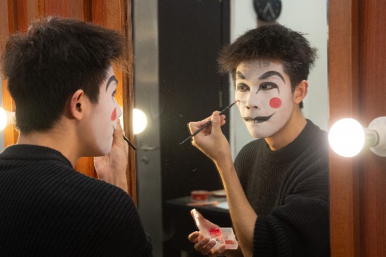A face-changing performer applies makeup. In the Sichuan Opera version of 